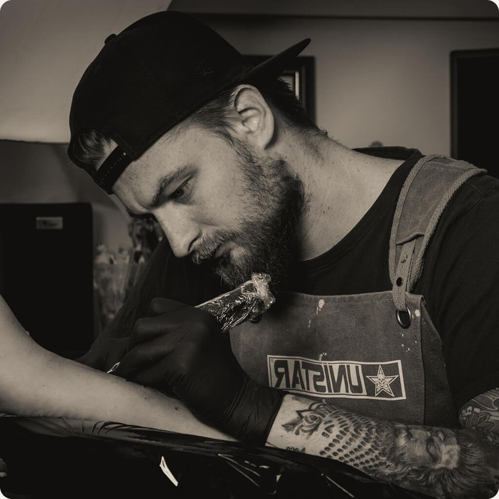 Tetoválóművész tetovál egy női alkarra