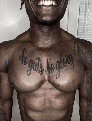 egy férfi mellkas tetoválása látható a képen, melyen egy felirat szerepel: No guts, No Glory