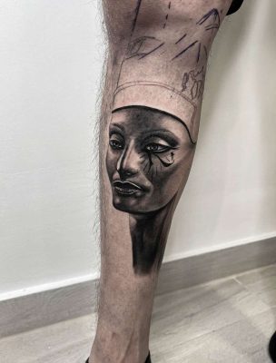 Realisztikus egyiptomi stílusú tetoválás lábszáron